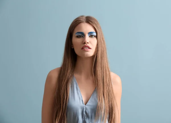 Vacker ung kvinna med ljus makeup på färgbakgrund — Stockfoto