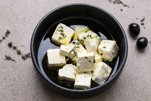 Placa con sabroso queso feta, tomillo y aceite de oliva sobre mesa gris — Foto de Stock