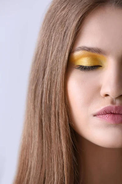 Krásná mladá žena s světlý make-up na světlé pozadí — Stock fotografie