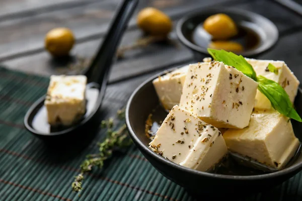 Bowl with tasty feta cheese in olive oil on table — Stock Photo, Image