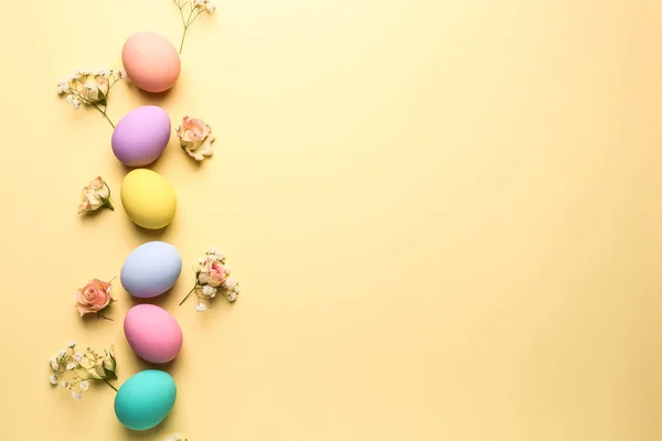 Uova di Pasqua con fiori su sfondo a colori — Foto Stock