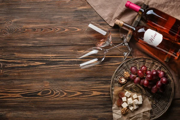 Композиция с вином и закусками на деревянном фоне — стоковое фото