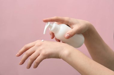 Doğal krem renk arka plan üzerinde şişe eller