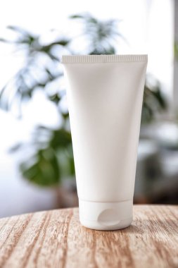 Ahşap masa üzerinde doğal krem ile tüp