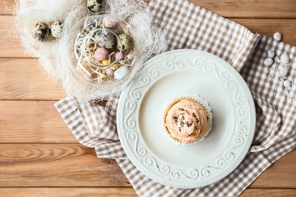 Plate with tasty Easter cupcake on wooden table — Stock Photo, Image