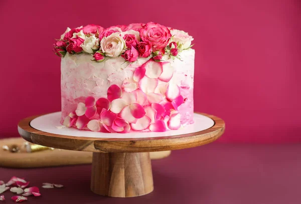 Renk arka plan üzerinde lezzetli doğum günü pastası ile stand — Stok fotoğraf