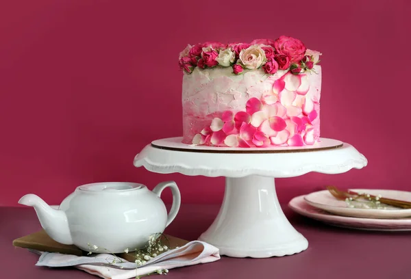 Stand con sabroso pastel de cumpleaños sobre fondo de color — Foto de Stock