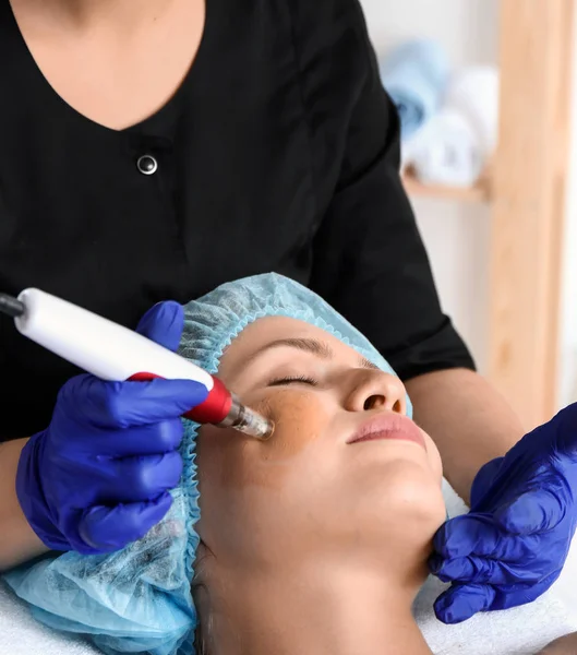 Молода жінка проходить процедуру світяться лікування в салоні краси — стокове фото