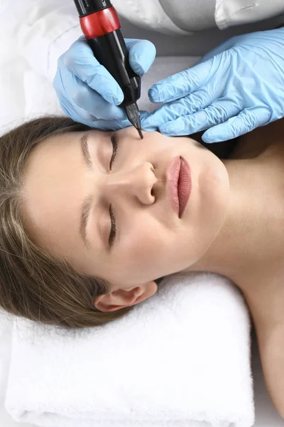 Young woman undergoing procedure of permanent makeup in beauty salon — Stock Photo, Image