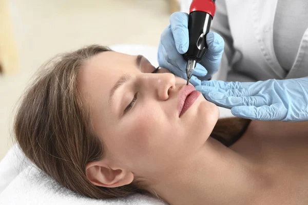 Young woman undergoing procedure of permanent makeup in beauty salon — Stock Photo, Image