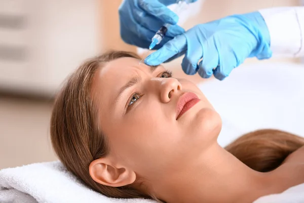 Mujer joven recibiendo inyección en salón de belleza — Foto de Stock