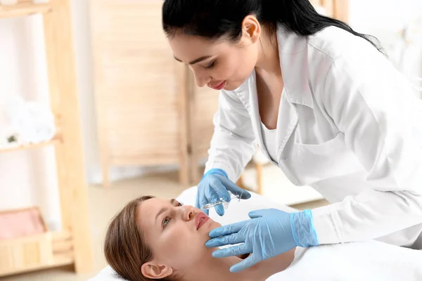 Young woman receiving injection in beauty salon — Stock Photo, Image