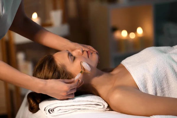 Jeune femme subissant une procédure de massage facial dans un salon de beauté — Photo