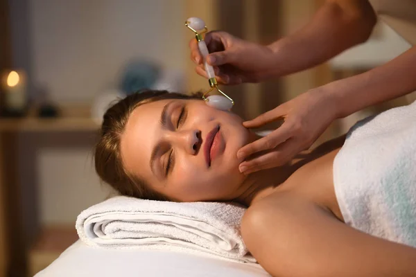 Young woman undergoing procedure of facial massage in beauty salon — Stock Photo, Image