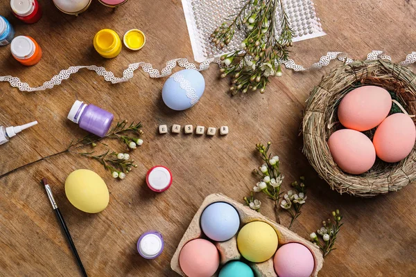 Πολύχρωμα Πασχαλινά αυγά και χρώματα στο τραπέζι — Φωτογραφία Αρχείου