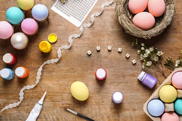 Colorful Easter eggs and paints on table — Stock Photo, Image