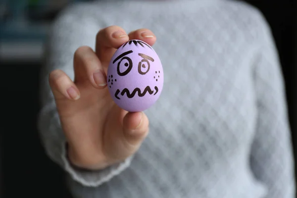 Komik çizilmiş yüz, kapatmak ile Paskalya yumurtası tutan kadın — Stok fotoğraf