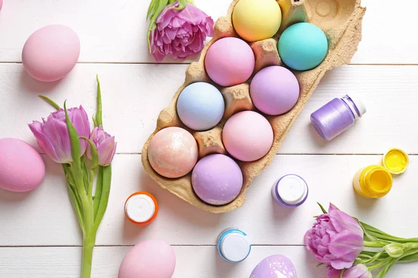 Colorful Easter eggs and paints on table — Stock Photo, Image