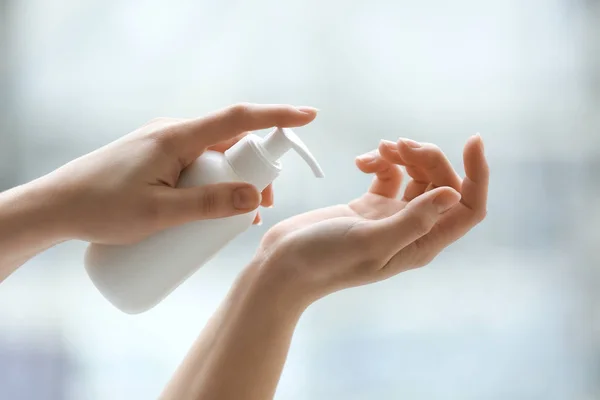 Mãos de mulher jovem aplicando creme em casa — Fotografia de Stock