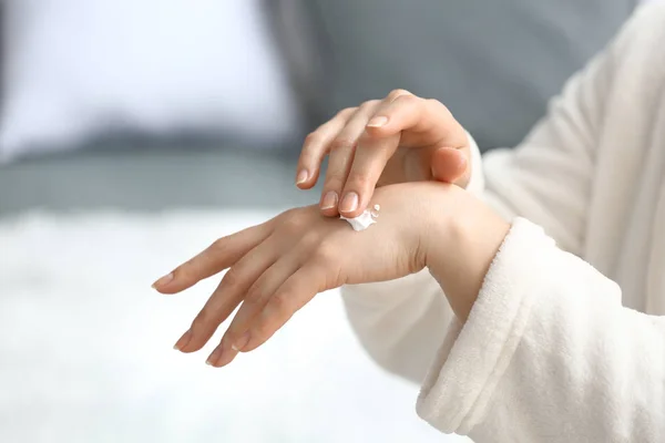 Young woman applying hand cream at home — Stock Photo, Image