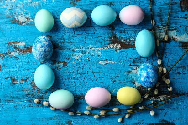 Telaio fatto di belle uova di Pasqua su sfondo di legno a colori — Foto Stock