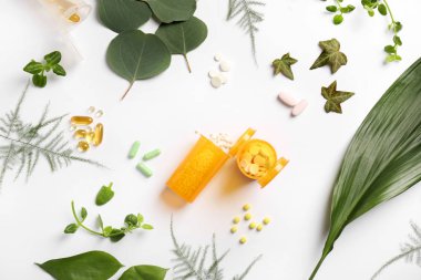 Kavanoz hapları ve beyaz arka plan üzerinde otlar ile