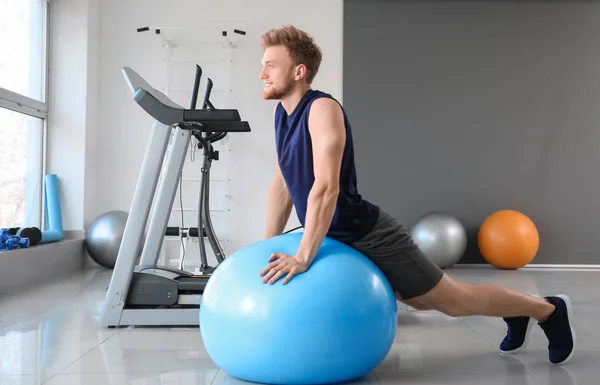 Sporty young man training with fitball in gym — Stock Photo, Image