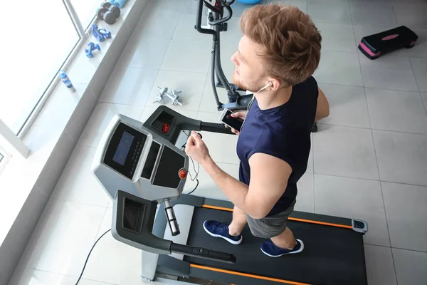 运动青年在健身房跑步机上训练 — 图库照片