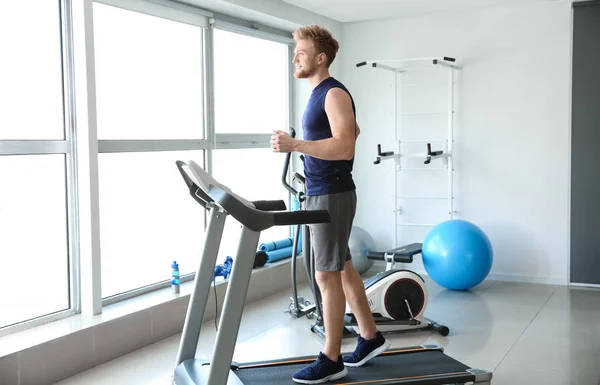 Sporty young man training on treadmill in gym — Stock Photo, Image