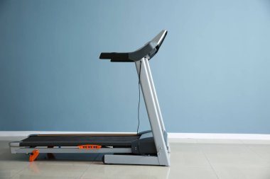 Spor salonunda renkli duvara yakın modern koşu bandı