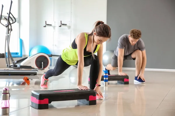 Sporty young people training in gym — Stock Photo, Image