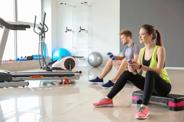 Sporty young people resting after training in gym — Stock Photo, Image