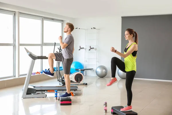 Sporty young people training in gym — Stock Photo, Image