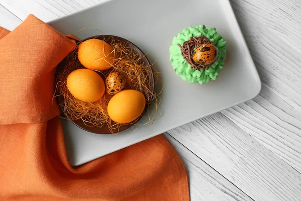 Placa con sabroso cupcake de Pascua y huevos en la mesa de madera —  Fotos de Stock