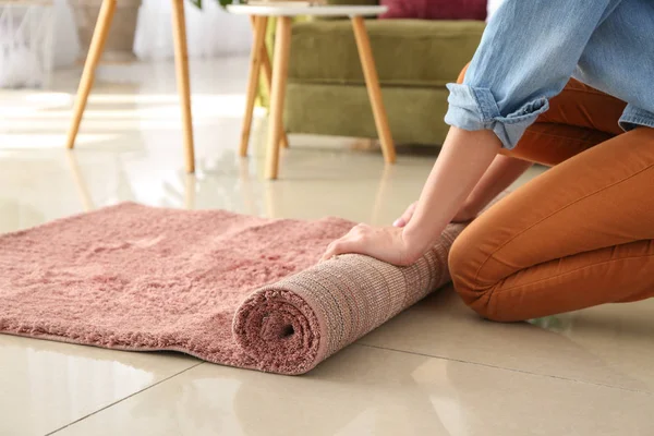 Woman rolling carpet at home — Stock Photo, Image