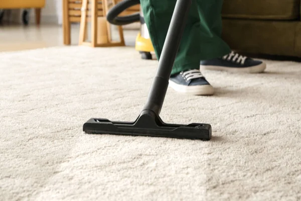 Tapete de limpeza do trabalhador com hoover — Fotografia de Stock