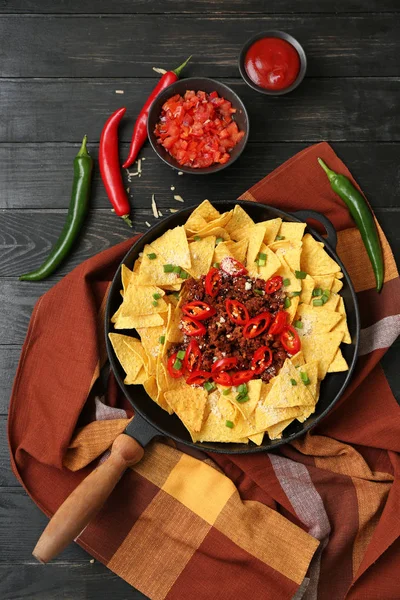 Sartén con sabrosos nachos, carne picada y chile sobre mesa de madera — Foto de Stock