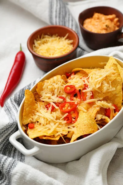 Ovenschaal met smakelijke nachos, kaas en Chili op tafel — Stockfoto