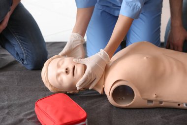 CPR ilk yardım eğitim kursu, manken üzerinde gösteren eğitmen