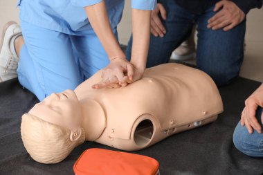 CPR ilk yardım eğitim kursu, manken üzerinde gösteren eğitmen