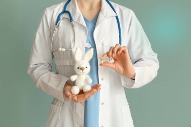 Oyuncak tavşan ve pill renk arka plan üzerinde çocuk doktoru