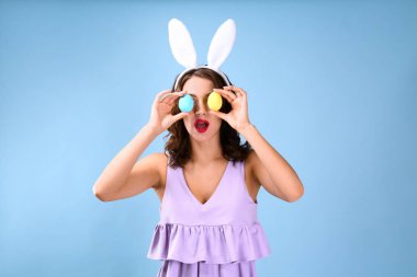 Tavşan kulakları ve Paskalya yumurtaları renkli arka plan üzerinde olan güzel kadın