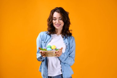 Renkli arka planda Paskalya yumurtaları ile güzel genç kadın