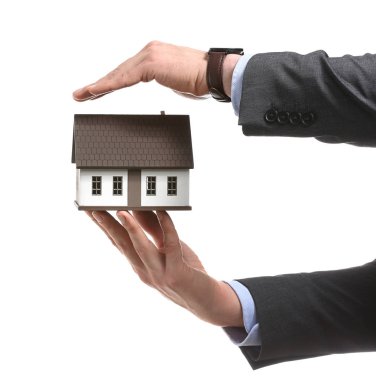 Evin beyaz arka plan üzerinde model ile sigortacı. Deprem evden korunması