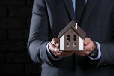 Koyu arka plan, closeup şirketten modeli ile sigortacı. Deprem evden korunması