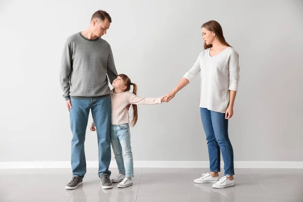 Unhappy family after divorce against light wall — Stock Photo, Image