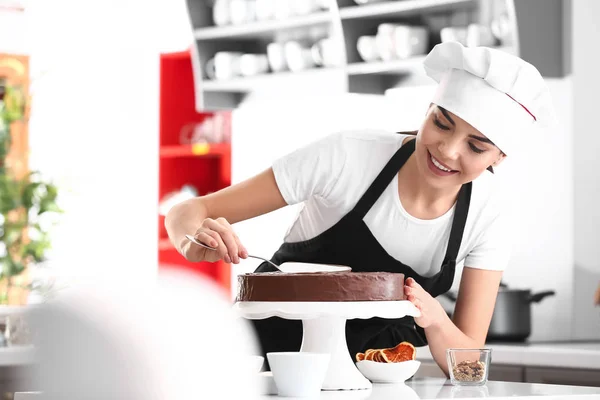 Jonge vrouwelijke banketbakkerij koken smakelijke taart in de keuken — Stockfoto