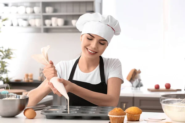 年轻的女糖果师烹饪松饼在厨房 — 图库照片