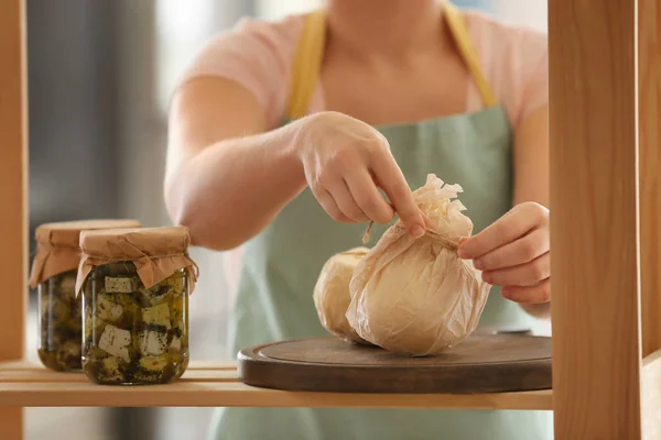 Kvinna kontrollera smakrik ost på hyllan i köket — Stockfoto