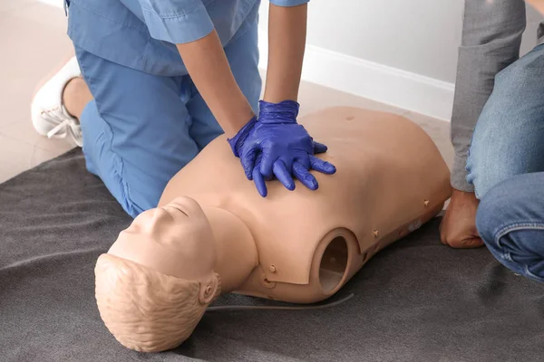 Instructor demonstrating CPR on mannequin at first aid training course — Stock Photo, Image